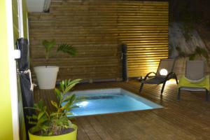 莱特鲁瓦西莱LES VILLAS TARA ET ANAIS的露台设有热水浴池,甲板上设有椅子