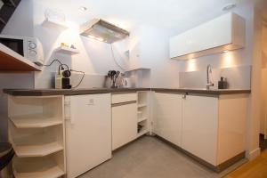 凡尔赛Le Duplex的厨房配有白色橱柜和水槽