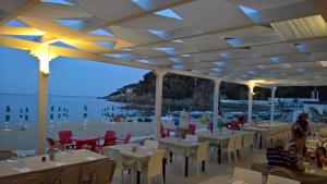 斯塔莱蒂伊尔甘比亚诺酒店的海滩上的餐厅,配有桌椅