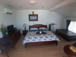 沙美岛农略客房酒店的一间卧室配有一张床和一把椅子