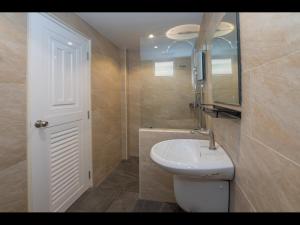芭堤雅市中心Tuk’s Sports Bar的浴室设有白色水槽和镜子
