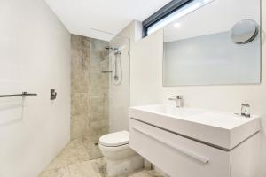 卡巴雷塔海滩Beachfront Cabarita Apartment by Kingscliff Accommodation的一间带水槽、卫生间和镜子的浴室