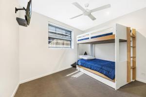 卡巴雷塔海滩Beachfront Cabarita Apartment by Kingscliff Accommodation的一间卧室配有双层床和吊扇