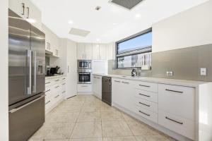 卡巴雷塔海滩Beachfront Cabarita Apartment by Kingscliff Accommodation的一间设有白色橱柜和窗户的大厨房