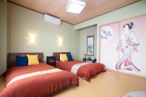 函馆Guesthouse tomoeドットコム的一间卧室设有两张床,墙上挂着一幅画