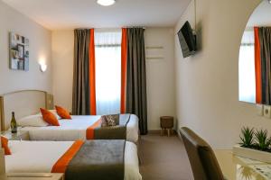 图尔尼蜂鸟酒店的酒店客房设有两张床和一张桌子。