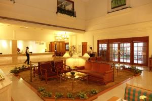 科钦阿巴德中庭酒店的大堂设有带沙发和椅子的客厅