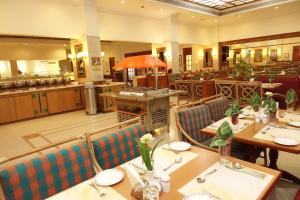 科钦阿巴德中庭酒店的餐厅内带桌椅的用餐室