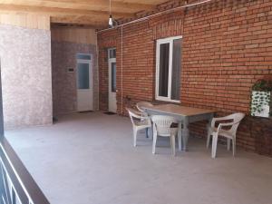 博尔若米Apartament LashaGiorgi的一个带桌椅和砖墙的庭院