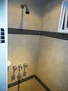 马德普拉塔艾尔斯苏尔酒店的浴室铺有黑白瓷砖,设有淋浴。