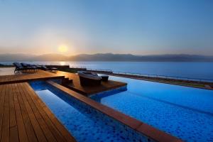 埃拉特Herbert Samuel Royal Shangri-La Eilat的游泳池,阳光下在水面上