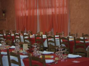 Bovolone达嘉尼餐厅酒店的一间用餐室,配有红色的桌椅和红色的窗帘