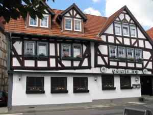 阿尔斯费尔德餐厅/迈因策尔图尔膳食旅馆的黑色和白色的建筑,窗户上装有鲜花