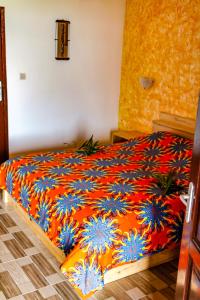 洛美罗宾逊海滨酒店的一间卧室配有一张带橙色和蓝色毯子的床