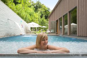萨尔嫩Seehotel Wilerbad Spa & Seminar的躺在游泳池里的年轻女孩