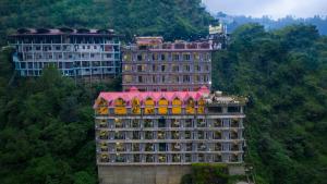 西姆拉Snow Valley Resorts Shimla的山上有红色屋顶的大建筑