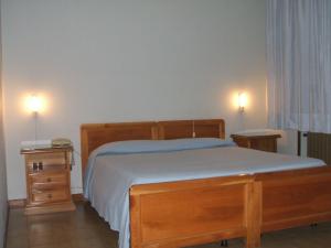 Bovolone达嘉尼餐厅酒店的一间卧室配有木床和2个床头柜