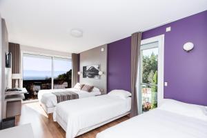 克罗泽特Hôtel-Restaurant Bois Joly的一间卧室设有两张床和紫色墙壁