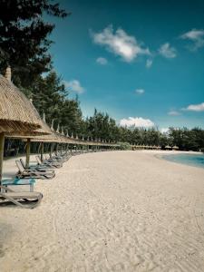 Beau Champ安娜希塔高尔夫及Spa度假酒店的海滩上一排沙滩椅和遮阳伞
