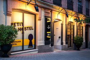 马德里Petit Hostel La Latina的建筑物窗户上标有标志的前方商店