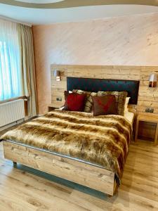 沃尔夫斯堡Boutique Hotel Goldene Henne的一间卧室配有一张大床和木制床头板