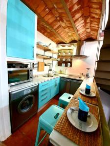 隆达Almocabar Luxury Apartment的厨房配有水槽和一张带蓝色凳子的桌子