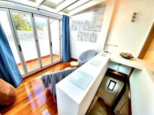 隆达Almocabar Luxury Apartment的客厅配有桌子和一些窗户