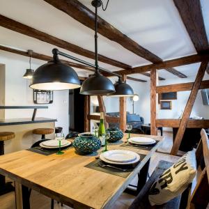 科尔马La Maison du Batelier的一间设有木桌和黑灯的用餐室