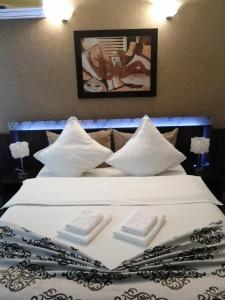皮特什蒂Casa Teilor的一张白色大床,上面有两张折叠毛巾