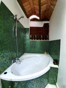 隆达Almocabar Luxury Apartment的浴室铺有绿色瓷砖,配有浴缸。