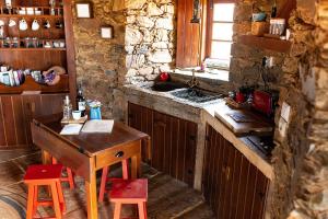 马桑Moinho da Fadagosa的厨房配有木桌和水槽。