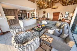 侯斯普瑞特Moya Safari Lodge & Villa的开放式客厅配有沙发和椅子