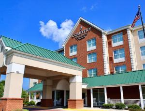弗雷德里克斯堡Country Inn & Suites by Radisson, Fredericksburg, VA的享有酒店正面的美国国旗