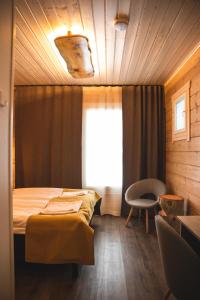 坦卡瓦亚坦卡瓦拉黄金乡村酒店的一间卧室设有一张床、一个窗口和一把椅子