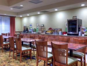 弗雷德里克斯堡Country Inn & Suites by Radisson, Fredericksburg, VA的一间带木桌椅的餐厅和一间酒吧