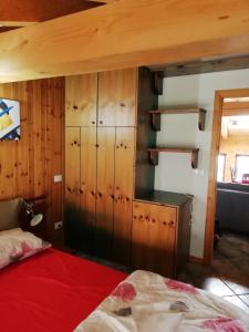 尚波尔谢Mansarda的一间卧室配有一张床和一个木制橱柜