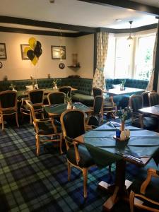 GlenfargThe Bein Inn Hotel & Restaurant的一间带桌椅的餐厅和一间候客室