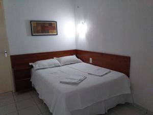 维索萨-杜塞阿拉Flat Matriz的一间卧室配有一张床,上面有两条毛巾
