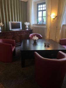 格尔斯费尔德Hotel Krone Post的客厅配有桌椅和电视。