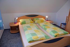 Klein ZickerFerienwohnungen Familie Looks的一间卧室配有一张带2个床头柜的大床