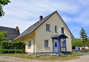 Klein ZickerFerienwohnungen Familie Looks的蓝色门的小黄色房子