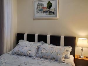 马尼拉Jen's Paranaque City Apartment的一间卧室配有一张带黑白床头板的床