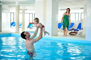 梅尔·莱斯·拜恩斯歌莉娅美人好时代公寓酒店的把婴儿抱在游泳池里的男人