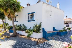 莫托拉Mértola Natural - Monte da Eirinha的白色的房子,有蓝色的长凳和棕榈树