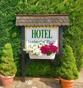 雷达-维登布吕克Landgasthof Rheda Hotel - Restaurant的花盆花的旅馆标志