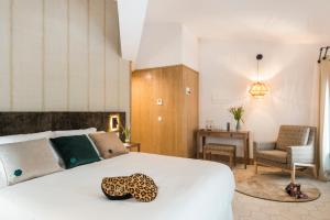 马翁Boutique Hotel Sant Roc & Spa的卧室配有一张白色大床和一把椅子