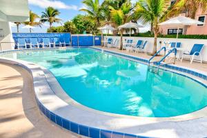 维洛海滩维洛海滩汽车旅馆的一个带蓝色椅子和棕榈树的大型游泳池