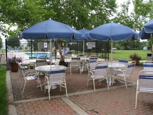 堪萨斯城酒店Extended Stay America - 堪萨斯城 - 机场 - 蒂芙尼泉的一组配有蓝色遮阳伞的桌椅