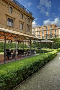 罗马斯普拉提特维里旅馆 - 世界小型豪华酒店的大楼前带桌椅的天井