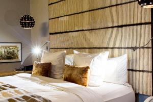 阿比让Boutique Hotel Particulier的一间卧室配有带白色床单和枕头的床。